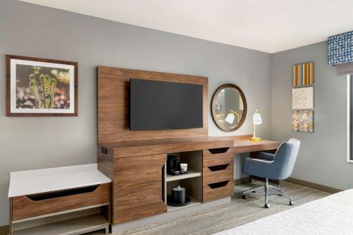 a bedroom with a desk and a television on a wall at Hampton Inn & Suites Olean, Ny in Olean