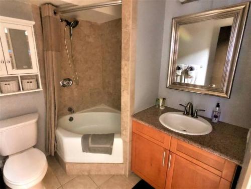 a bathroom with a sink and a tub and a toilet at KING BED, Spacious, Legal, VIEW in Honolulu