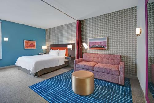 ブラックスバーグにあるHome2 Suites by Hilton Blacksburg Universityのベッドとソファ付きのホテルルーム