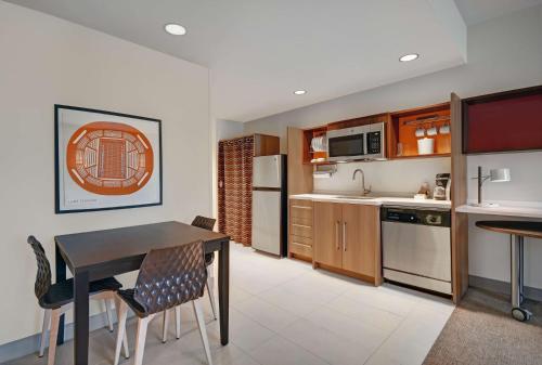 a kitchen with a table and chairs in a room at Home2 Suites by Hilton Blacksburg University in Blacksburg
