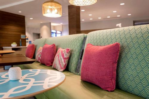 a row of pillows on a couch with a table at Home2 Suites By Hilton West Sacramento, Ca in West Sacramento