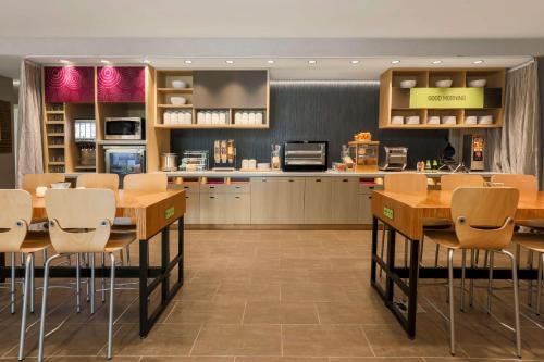a kitchen and dining room with tables and chairs at Home2 Suites By Hilton West Sacramento, Ca in West Sacramento