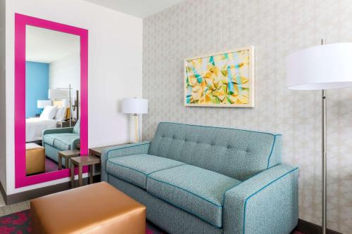 a living room with a blue couch and a bedroom at Home2 Suites By Hilton West Sacramento, Ca in West Sacramento