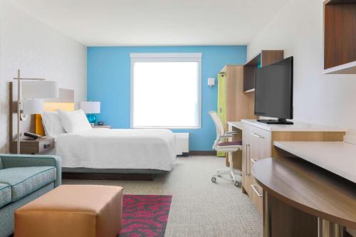 a hotel room with a bed and a tv at Home2 Suites By Hilton West Sacramento, Ca in West Sacramento