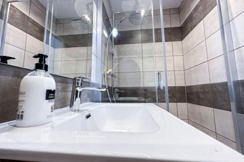 a bathroom with a sink and a bottle of soap at CAN ROMY APPARTEMENT T3 B - à 20m de la plage de Cala Montgo in L'Escala