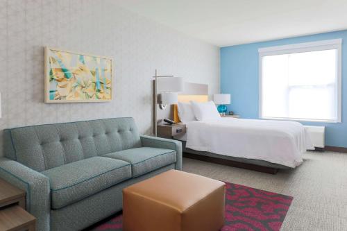 ウエスト・サクラメントにあるHome2 Suites By Hilton West Sacramento, Caのソファとベッド付きのホテルルーム