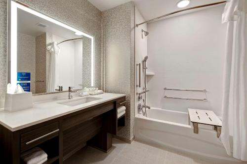 y baño con lavabo, bañera y ducha. en Home2 Suites By Hilton Lincolnshire Chicago, en Lincolnshire