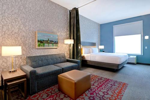 een hotelkamer met een bed en een bank bij Home2 Suites By Hilton Lincolnshire Chicago in Lincolnshire
