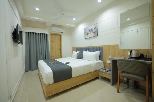 a hotel room with a bed and a desk and a desk at Hotel Shayan Inn in Rajkot