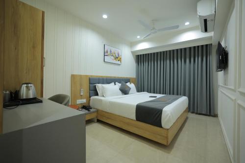 a hotel room with a bed and a desk at Hotel Shayan Inn in Rajkot