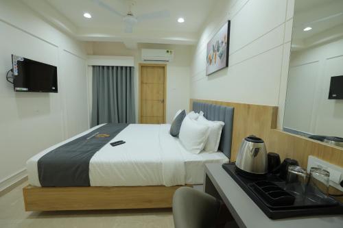 a hotel room with a bed and a kitchen at Hotel Shayan Inn in Rajkot