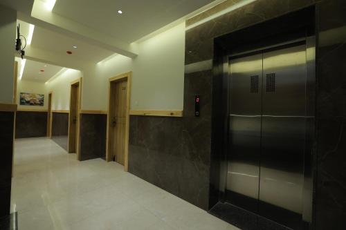 a hallway with a door in a building at Hotel Shayan Inn in Rajkot