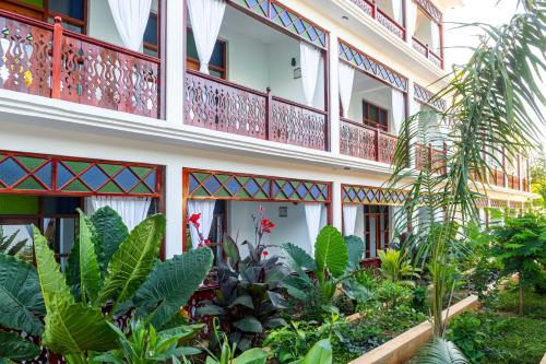 a building with a lot of plants in front of it at TASNEEM islamic luxury suites in Jambiani