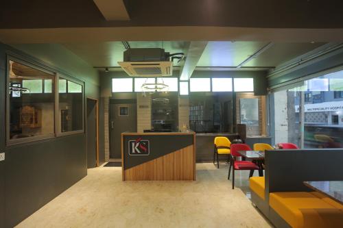 a restaurant with yellow chairs and a counter in a room at Hotel Shayan Inn in Rajkot