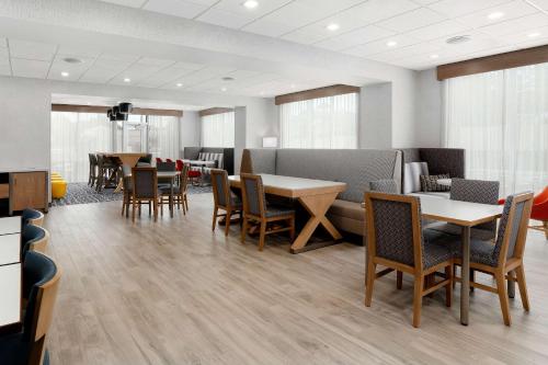 a dining room with tables and chairs and windows at Hampton Inn Bellingham Airport, WA in Bellingham