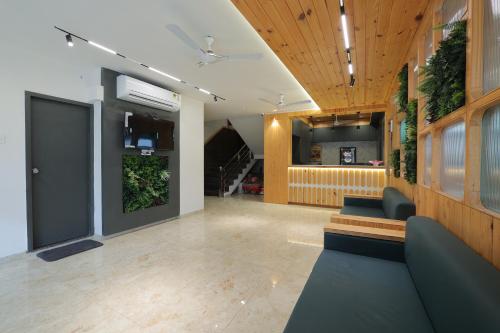 a lobby with couches and plants in a building at Hotel Shayan Inn in Rajkot