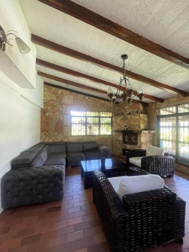 uma ampla sala de estar com um sofá e cadeiras em Finca Colonial / Lago Calima em Calima