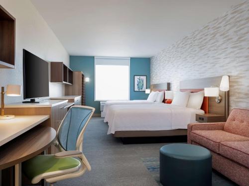 um quarto de hotel com uma cama e um sofá em Home2 Suites By Hilton Phoenix Avondale, Az em Avondale