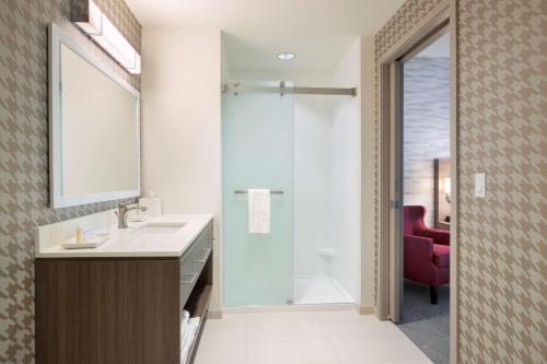 a bathroom with a sink and a shower with a mirror at Home2 Suites By Hilton Phoenix Avondale, Az in Avondale