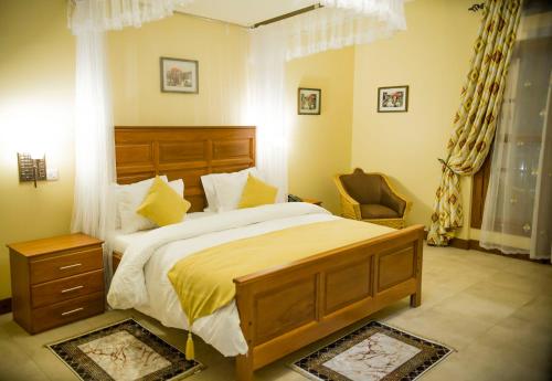 a bedroom with a large bed and a chair at Cornerstone Villas in Arusha