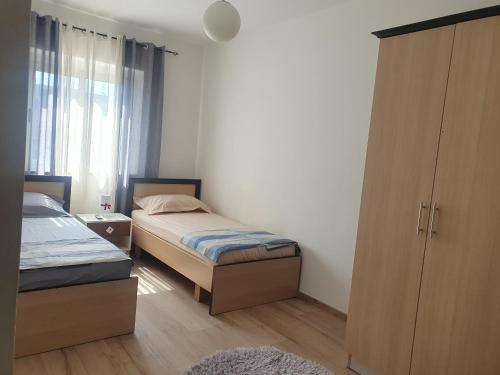 um quarto com 2 camas, um armário e uma janela em Apartment in the heart of Tirana , Bllok em Tirana
