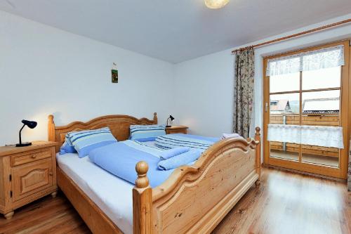 a bedroom with a large wooden bed with blue pillows at Ferienhaus Sommer in Pfronten