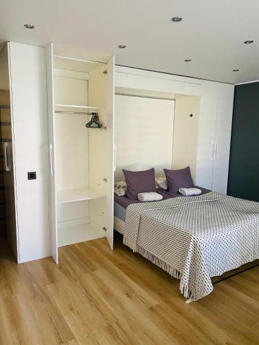 a bedroom with a bed with purple pillows at Apartment Ariella in Jūrmala