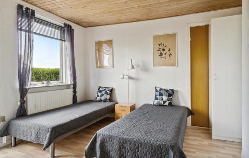 1 dormitorio con 2 camas y ventana en Awesome Home In Bandholm With 3 Bedrooms And Wifi, en Bandholm