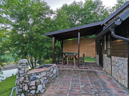 een patio van een huis met een stenen muur bij Vikendica na Drini DRINSKI ODMOR in Crnča