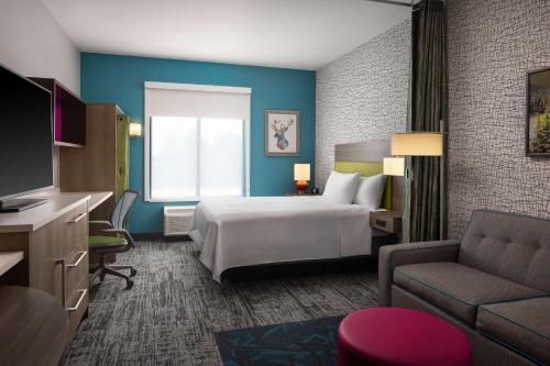 本德的住宿－Home2 Suites By Hilton Bend, Or，酒店客房配有床、沙发和电视。