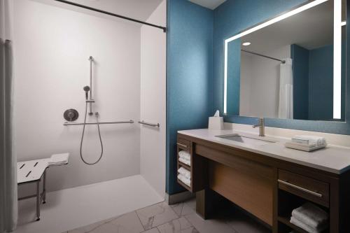 uma casa de banho com um lavatório e um chuveiro com um espelho. em Home2 Suites By Hilton Bend, Or em Bend
