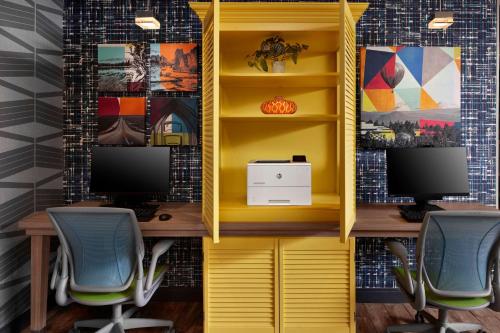 an office with a yellow cabinet with two computer monitors at Home2 Suites By Hilton Bend, Or in Bend