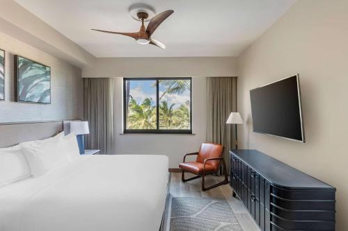 a bedroom with a bed and a flat screen tv at Hilton Grand Vacations Club Maui Bay Villas in Kihei