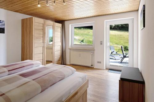 1 dormitorio con 2 camas y puerta corredera de cristal en Haus Fritz en Wittenschwand