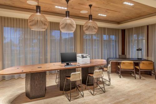 a room with a desk with a computer and chairs at Hilton Grand Vacations Club Maui Bay Villas in Kihei