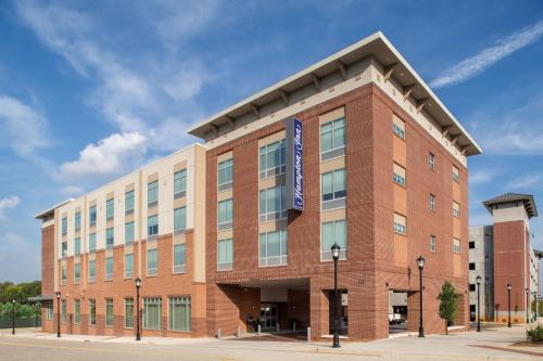 a large brick building with a blue sign on it at Hampton Inn Greer Greenville, Sc in Greer