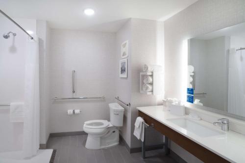La salle de bains blanche est pourvue de toilettes et d'un lavabo. dans l'établissement Hampton Inn Greer Greenville, Sc, à Greer