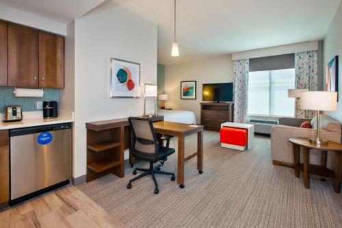 a hotel room with a kitchen and a desk in a room at Homewood Suites By Hilton Columbus Easton, Oh in Columbus