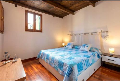 Un dormitorio con una cama azul y blanca y una ventana en Apartment Cavour, en Alghero