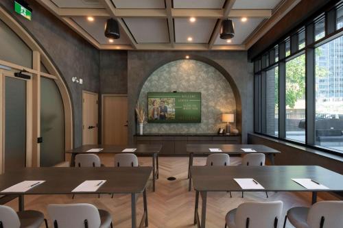 a dining room with tables and chairs and a tv at The Westley Calgary Downtown, Tapestry Collection By Hilton in Calgary