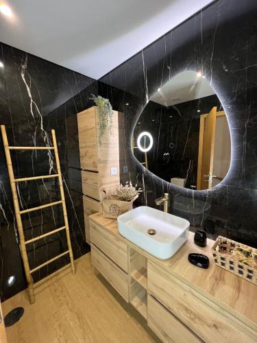 a bathroom with a sink and a mirror at Coruja’s House AL OPO in Porto