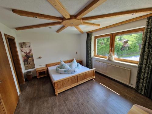 ein Schlafzimmer mit einem Bett und einem großen Fenster in der Unterkunft Gästehaus Schoeneweiß in Ehrwald