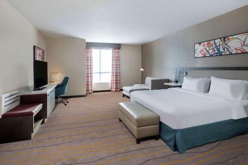 a hotel room with a large bed and a television at Hilton Garden Inn Chino Hills Pomona CA in Pomona