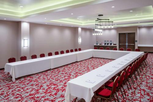 a large room with white tables and red chairs at Hilton Garden Inn Chino Hills Pomona CA in Pomona