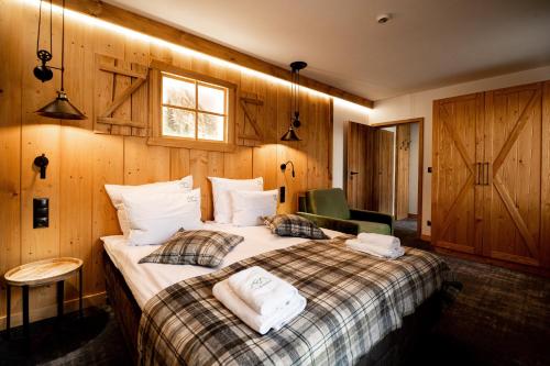 a bedroom with a large bed with wooden walls at Ku Dolinie in Kościelisko