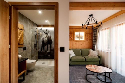 a living room with a green couch and a bathroom at Ku Dolinie in Kościelisko