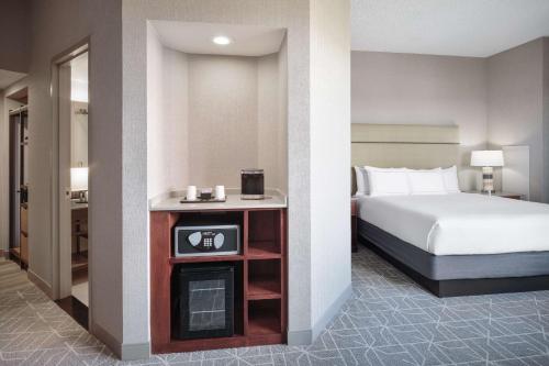 a hotel room with a bed and a table with a clock at Hilton Richardson Dallas, TX in Richardson