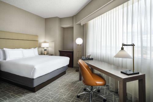 a hotel room with a bed and a desk at Hilton Richardson Dallas, TX in Richardson