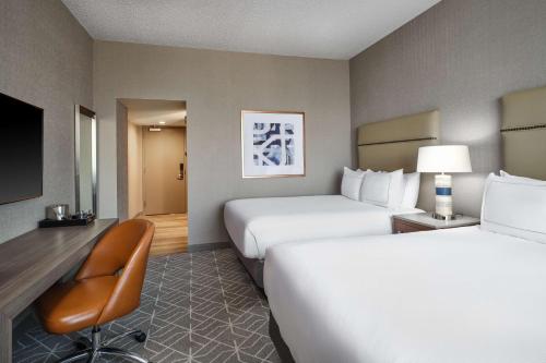 a hotel room with two beds and a chair at Hilton Richardson Dallas, TX in Richardson