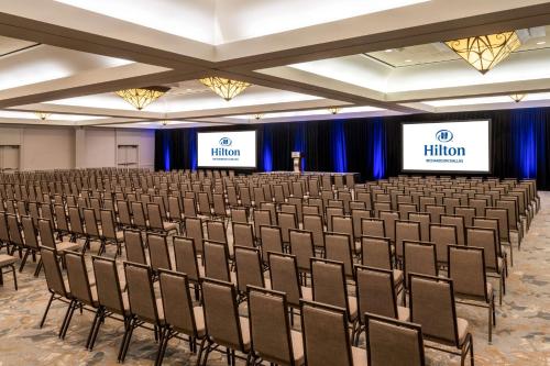 a conference room with chairs and two screens at Hilton Richardson Dallas, TX in Richardson
